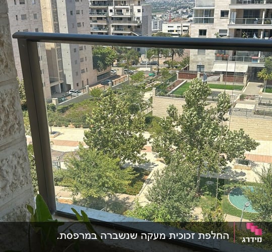 מעקה זכוכית במרפסת עם נוף עירוני